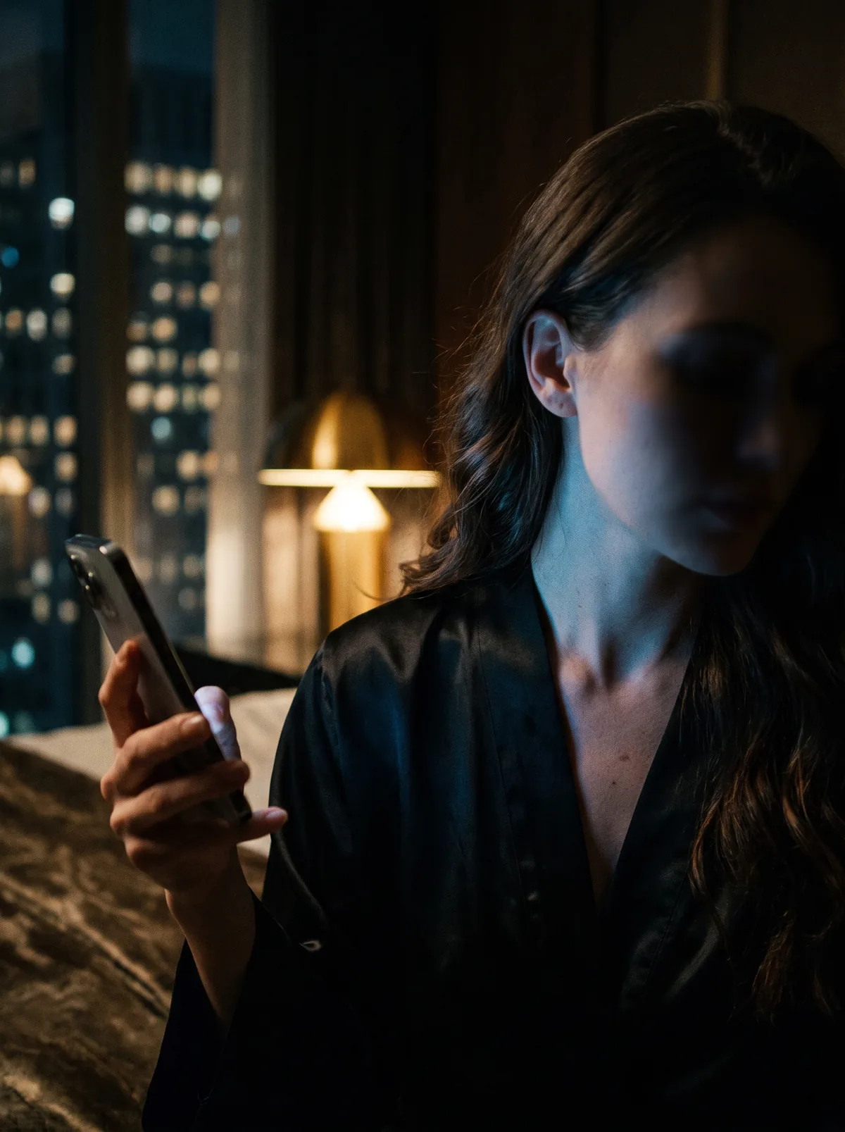 Over the shoulder of a creator holding up her phone in a dark room